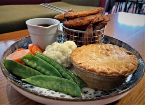 A restaurant cooked peas and pies and cauliflower and chips