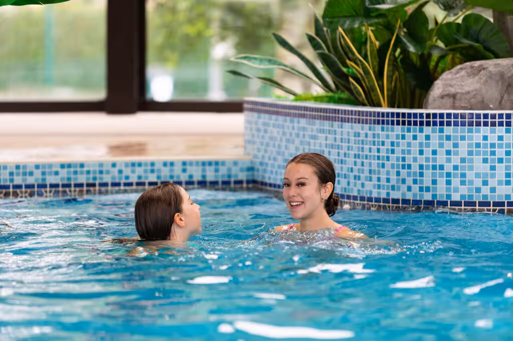 Lakeside inside swimming pool with two girls swimming