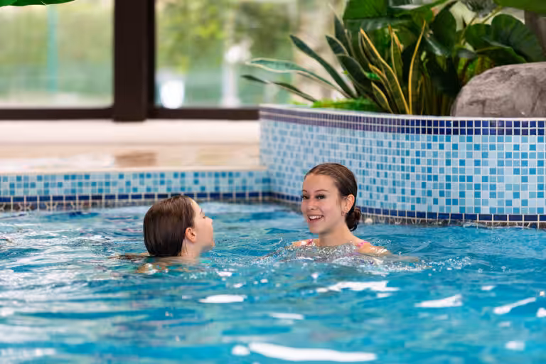 Lakeside inside swimming pool with two girls swimming