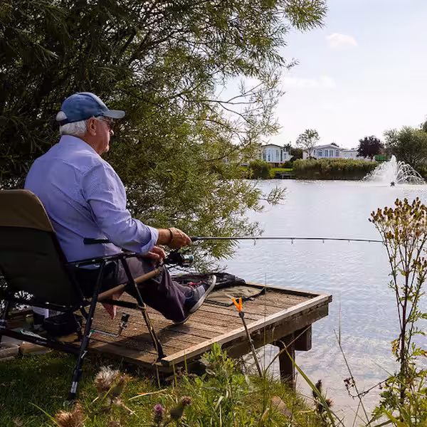 A man fishing in a Lake in Lakeside Park in Lincolnshire