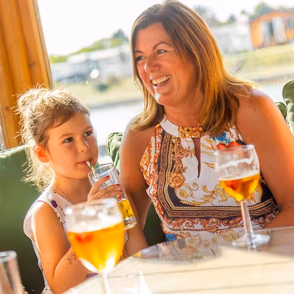 A mother and daughter at a restaurant at a Don Amott Park enjoying drinks