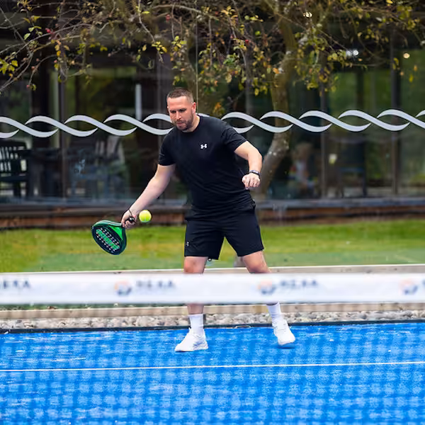 A man playing tennis on a court in a Don Amott park in Lincolnshire