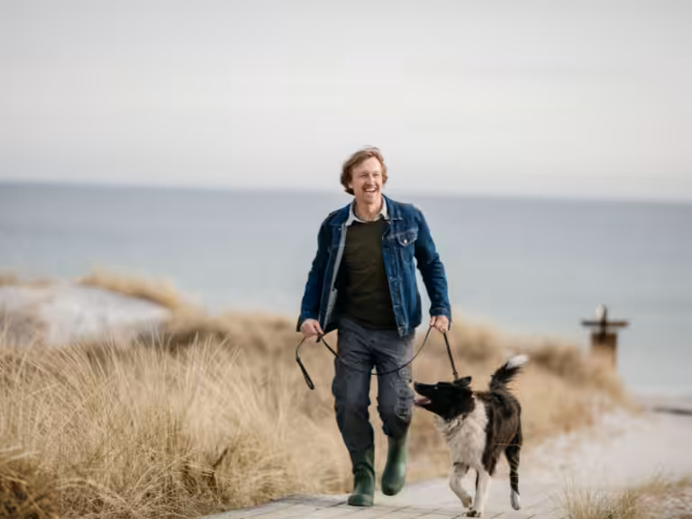 A man walking his dog on a beach in Skegness