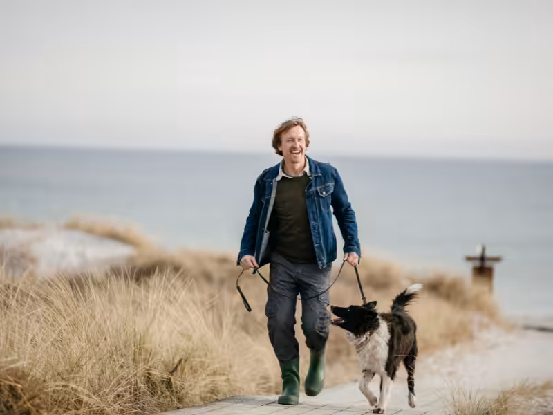 A man walking his dog on a beach in Skegness
