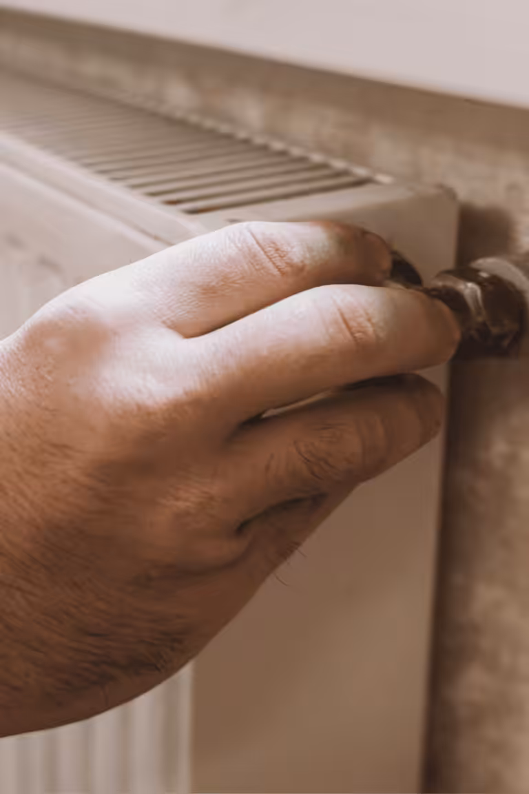 A man turning of his radiator in his holiday home