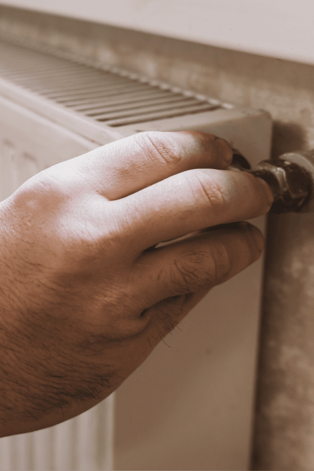 A man turning of his radiator in his holiday home
