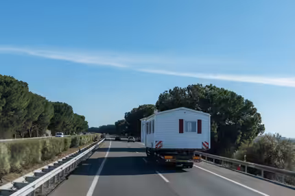 A truck carrying a holiday home bring on